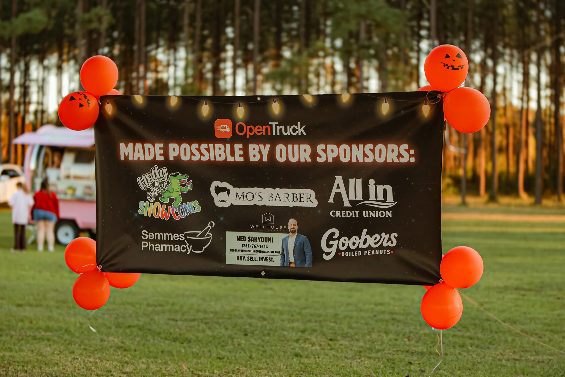 Movie night sponsor banner recognizing Holly Jolly Snowcones, Mo’s Barber, All In Credit Union, Semmes Pharmacy, Ned Sahyouni of Wellhouse Real Estate, and Goobers Boiled Peanuts